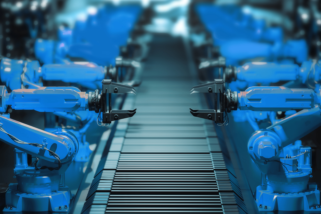 Auf dem Bild sind blaue Industrieroboter an einem Herstellungsband zu sehen.