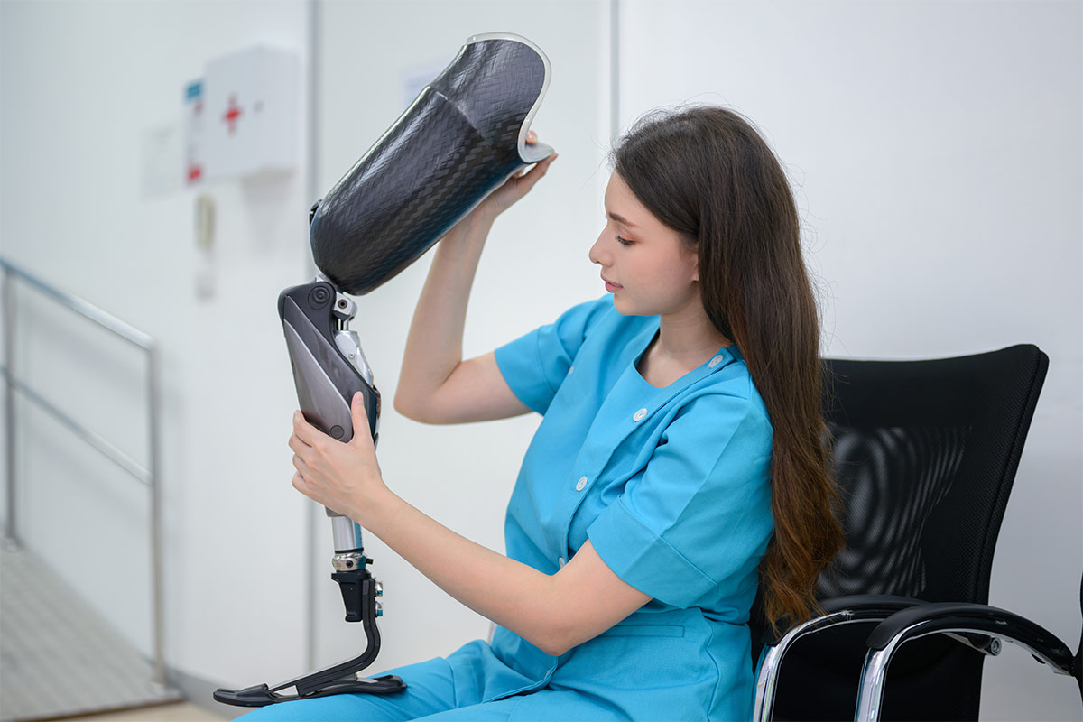 Eine Medizintechnikerin, die gerade dabei ist eine Beinprothese zusammenzusetzen 